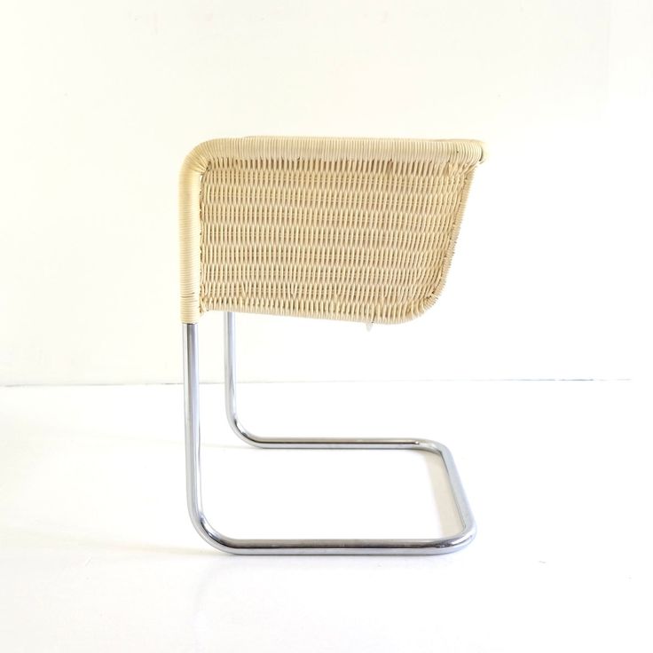 a white chair with a metal frame and wicker backrest on a white background