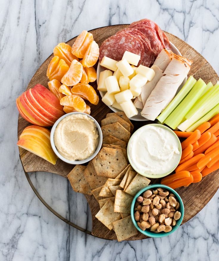 a platter filled with cheese, crackers and fruit