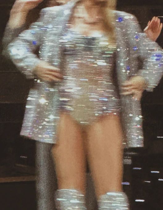 a woman in silver dress and boots on stage