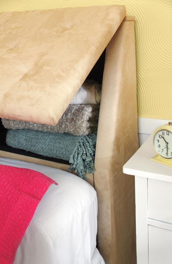 a bed that has some blankets on it and a clock in the corner next to it