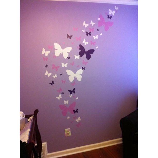 a baby's room with purple walls and butterflies on the wall