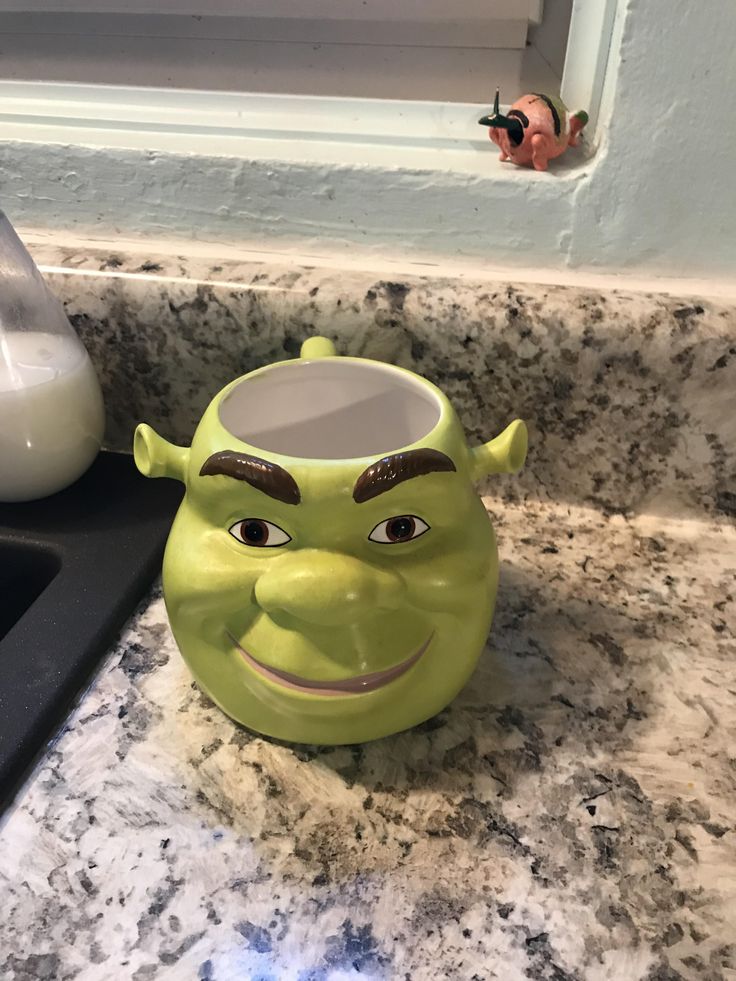 a green ceramic mug sitting on top of a counter