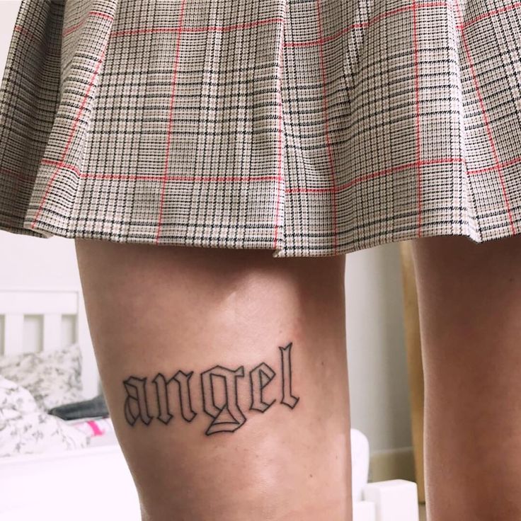 a woman's legs with the word angel tattooed on her lower leg in black ink