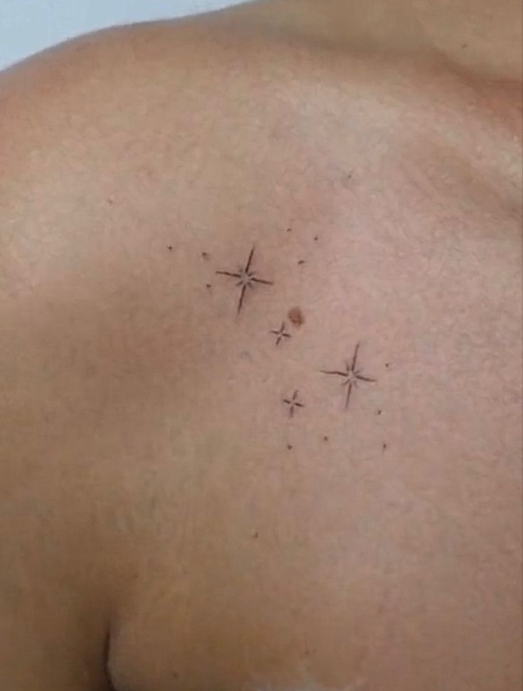 the back of a man's shoulder with three crosses on it