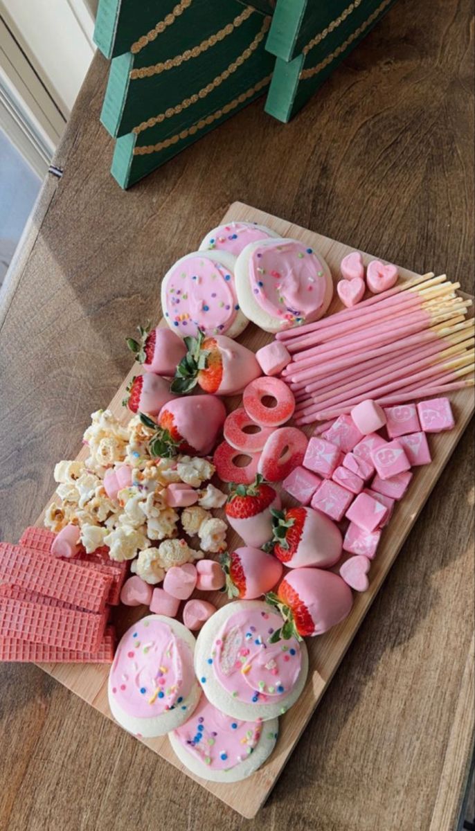 a wooden table topped with lots of candy and marshmallows on top of it