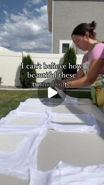 a woman sanding on top of a white table