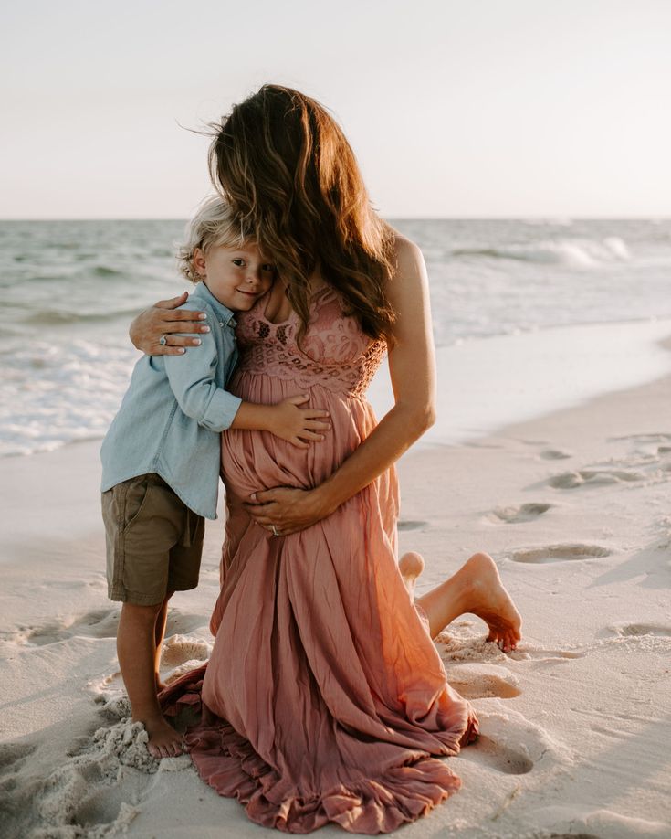 a woman holding a child on the beach