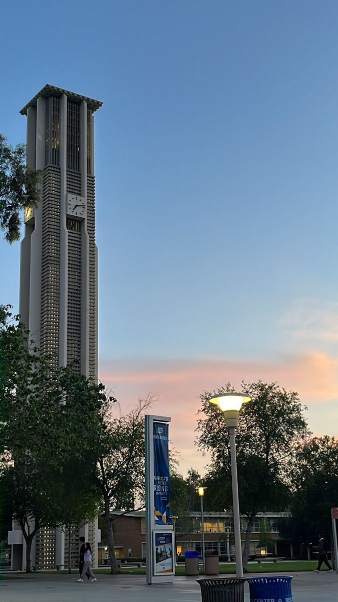 a tall clock tower sitting on the side of a road next to a street light