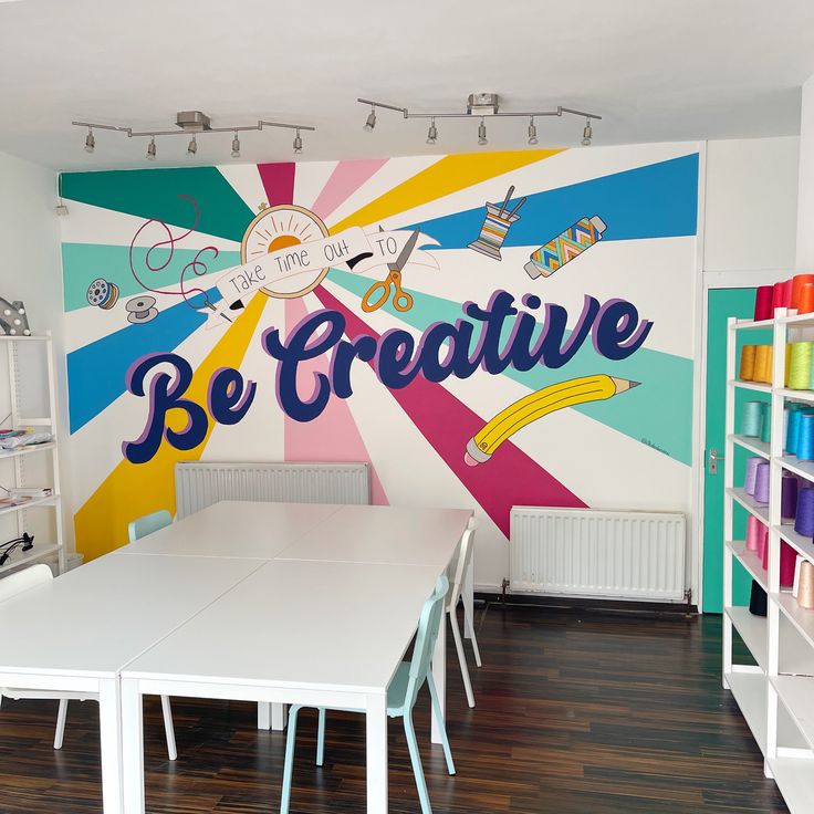 there is a large wall mural in the children's playroom that says be creative