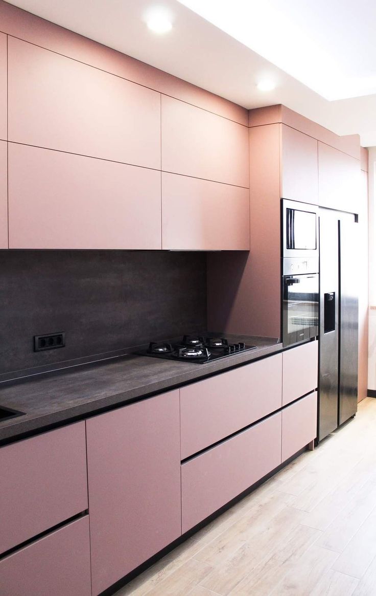 a kitchen with pink cabinets and stainless steel appliances