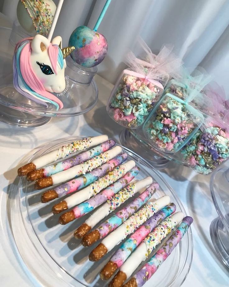 a table topped with lots of different types of candy and marshmallows on sticks