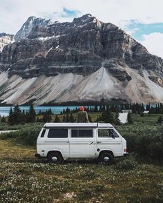 a van parked in the grass near mountains