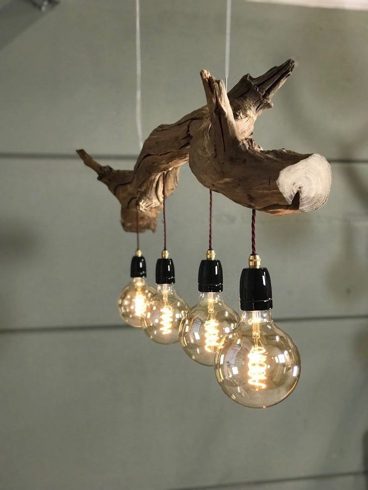 some light bulbs hanging from a ceiling with wood and glass globes on the strings