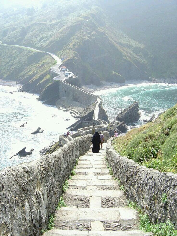 a person walking up some steps near the ocean