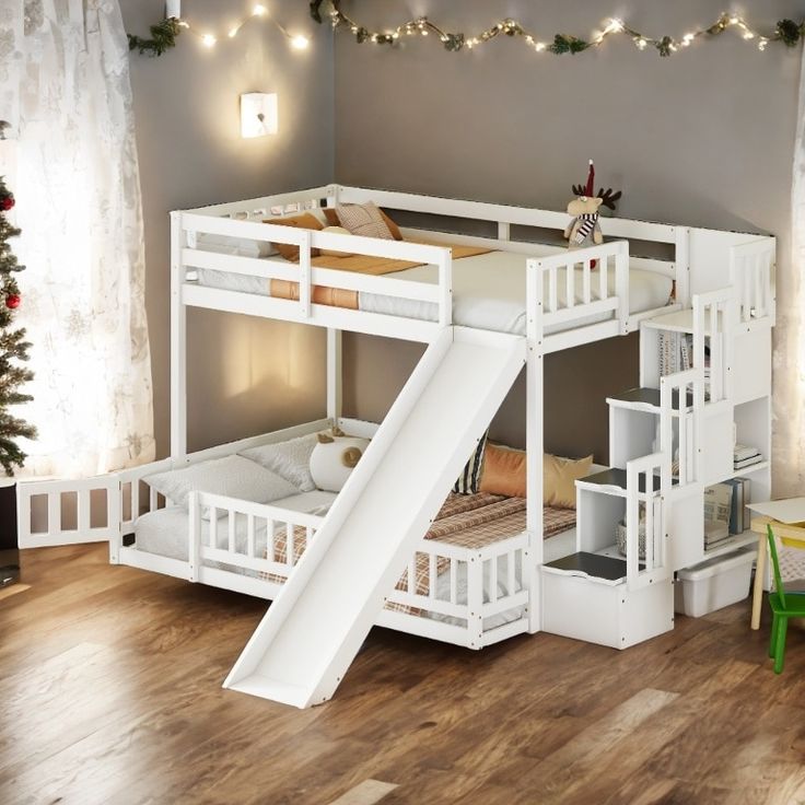 a white bunk bed with a slide next to it on top of a hard wood floor