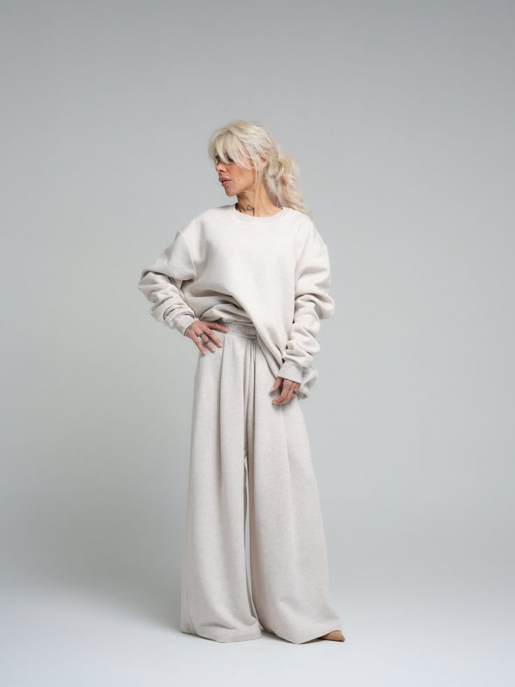 Find your comfort zone in our ecru loungewear set, a perfect marriage of style and relaxation. This ensemble, made from a cotton and polyester blend, provides both the softness of cotton and the durability of polyester. The set includes a relaxed-fit sweatshirt and coordinating wide-leg pants, both designed to offer you a luxurious feel and a chic, understated look. FEATURES: Oversized sweatshirt with drop shoulders for a modern silhouette. High-rise with a wide-leg cut to complement the relaxed Women’s Loungewear, Elevated Loungewear Outfits, Stylish Homewear, Monochrome Loungewear, Unisex Loungewear, Feminine Loungewear, Lounge Set Outfit, Moodboard Branding, Concept Moodboard