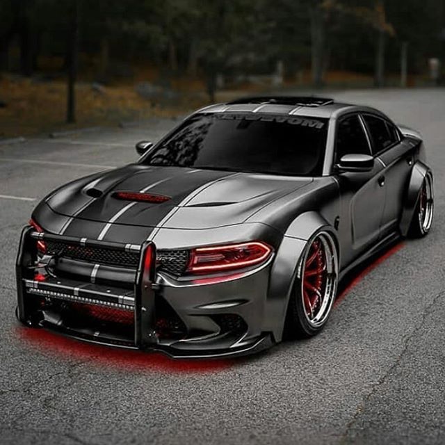 a gray sports car parked in a parking lot with red lights on it's side