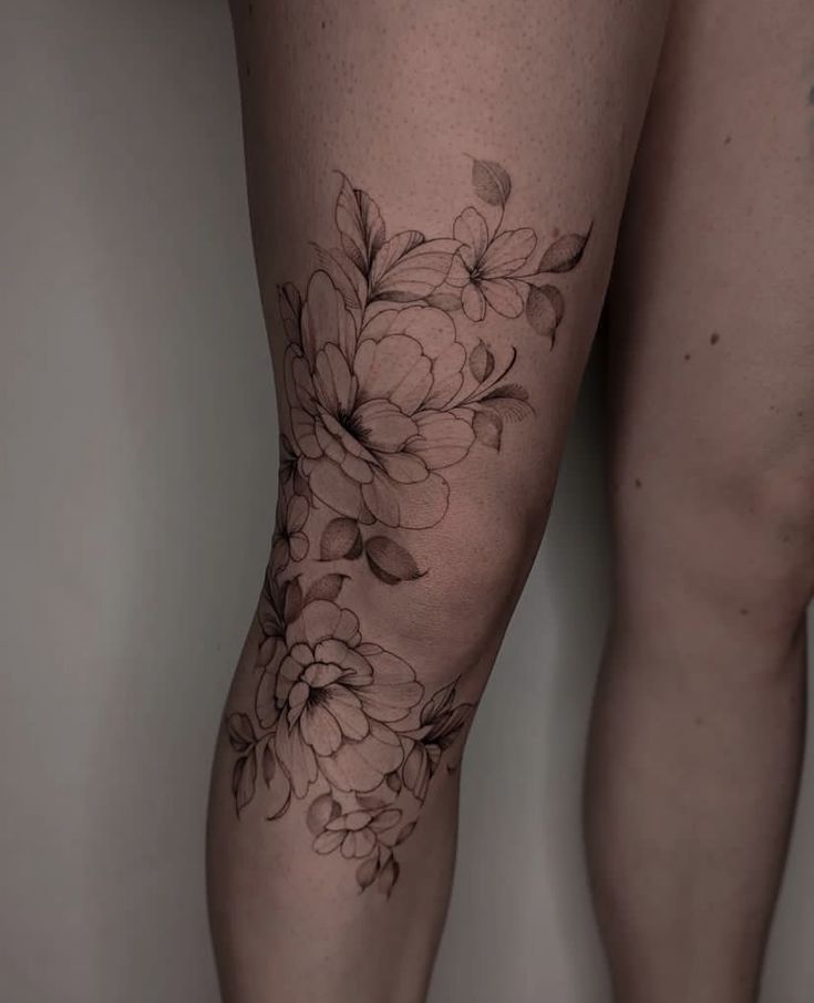 a woman's legs with flowers tattooed on them