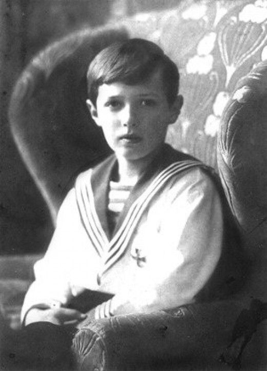 a young boy sitting in a chair with his arms crossed and looking at the camera