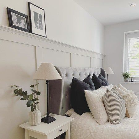 a bed with white sheets and black pillows