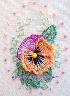 a close up of a flower on a piece of cloth with bead work around it