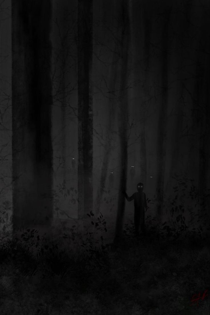 a man standing in the middle of a forest at night