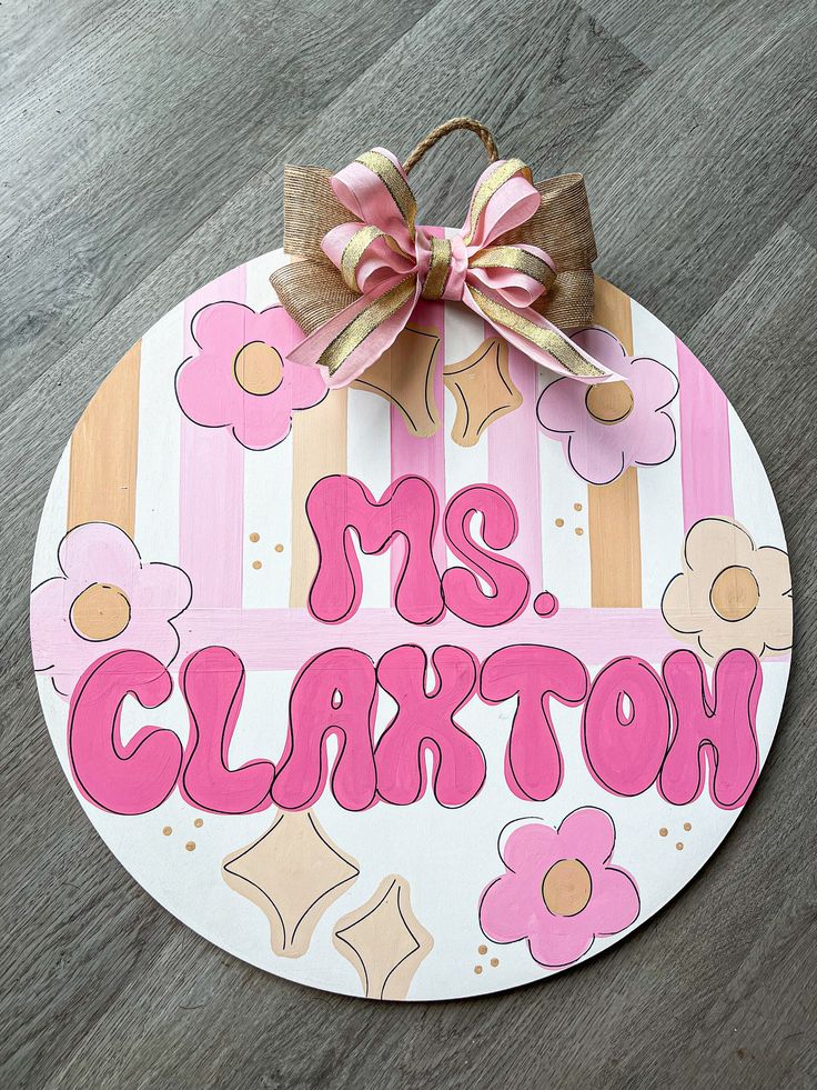 a wooden sign that says mrs clarton with flowers on it and a bow