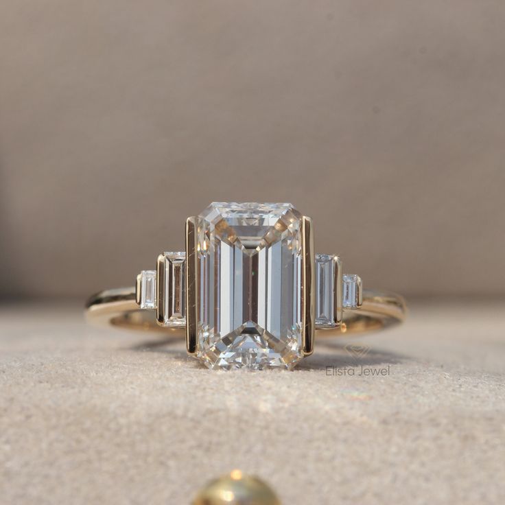 an emerald cut diamond ring with three baguets