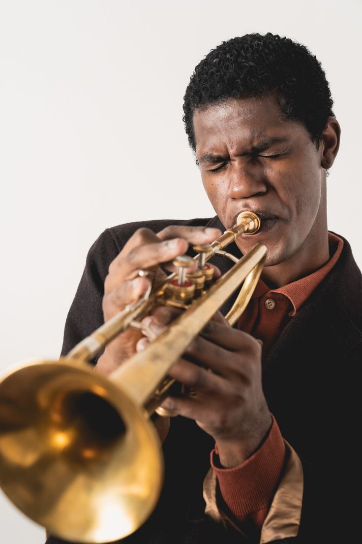 a man playing a trumpet in front of a white background