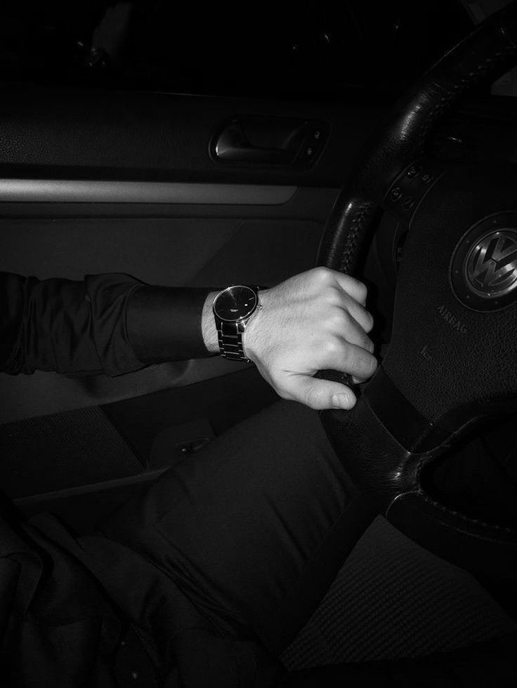 a man wearing a watch while sitting in a car