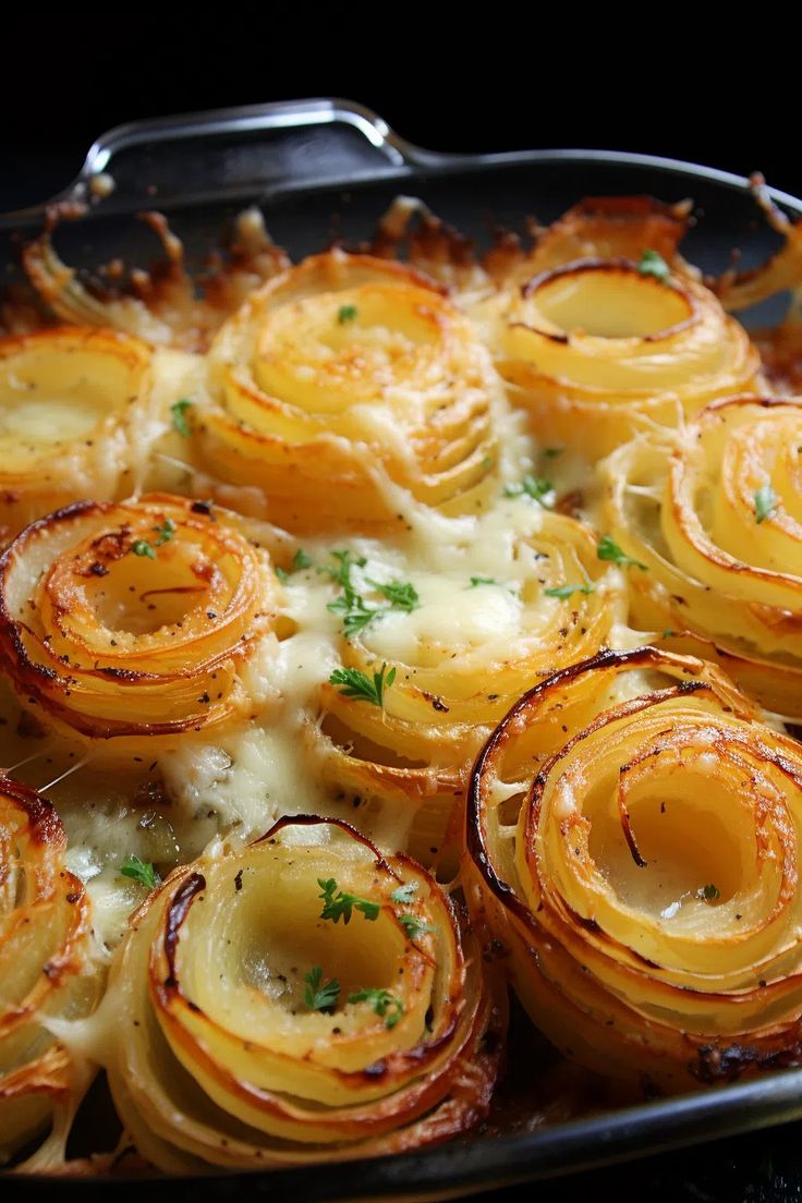 baked potatoes with parmesan cheese and herbs in a casserole dish, ready to be eaten