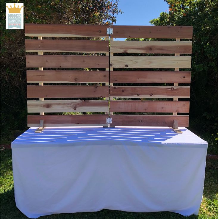 a table with a blue and white cloth on it in front of a wooden fence