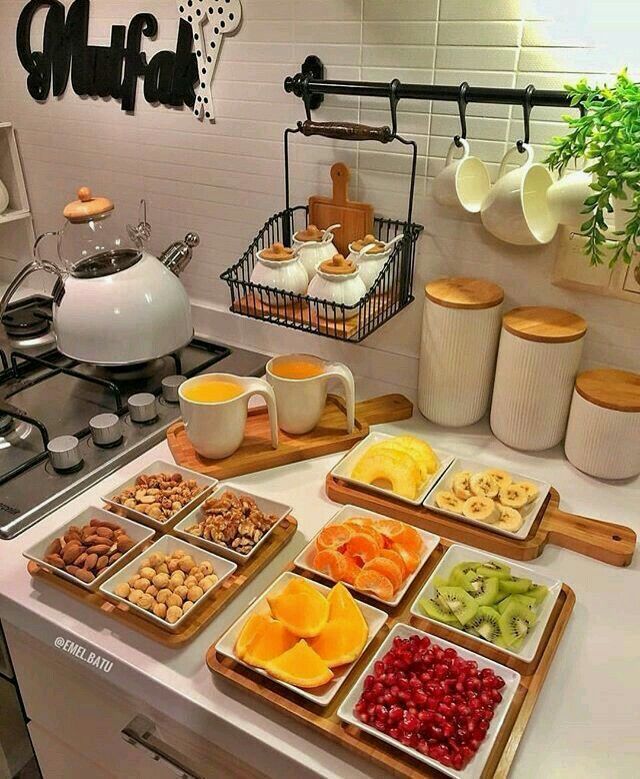 a kitchen counter topped with lots of trays filled with different types of fruits and nuts