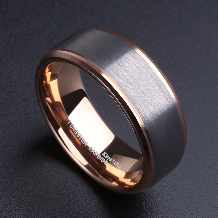 an image of a wedding ring on a black surface with gold inlaying the center