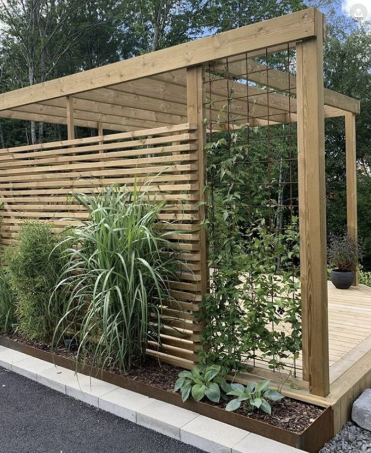 a wooden gazebo surrounded by plants and trees