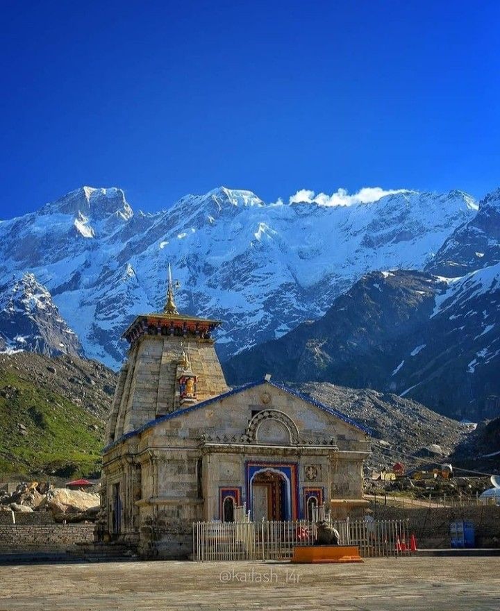 an old church in front of snowy mountains