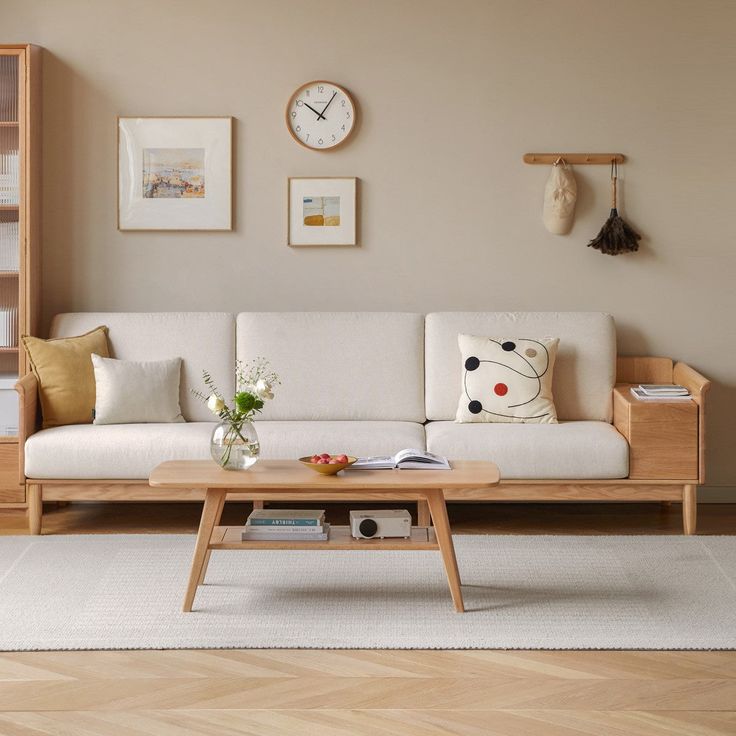 a living room with a couch, coffee table and bookshelf on the wall