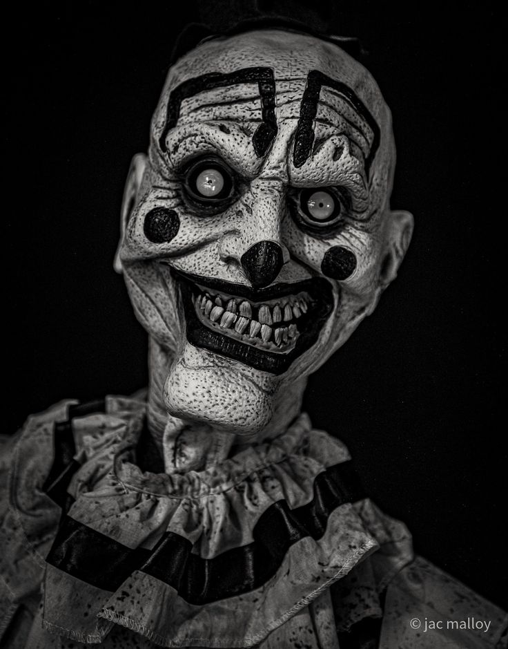 a creepy clown with black and white makeup