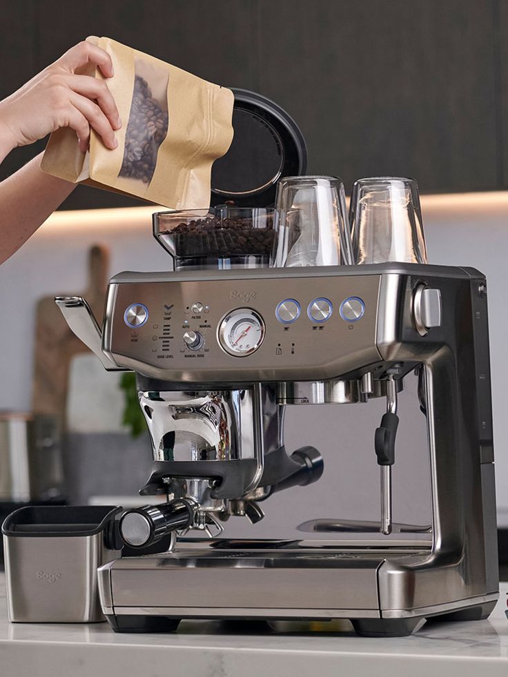 a person is pouring something into a coffee machine