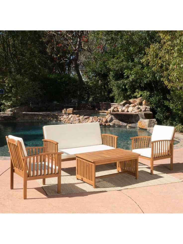 an outdoor patio furniture set near a pool