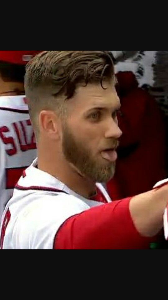 a baseball player is standing in the dugout with his hand out to someone else