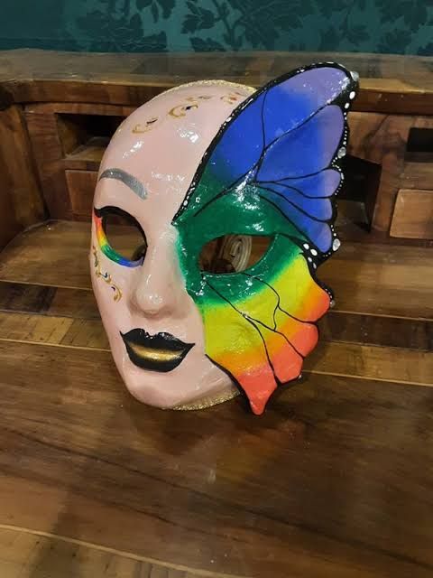 a colorful mask sitting on top of a wooden table