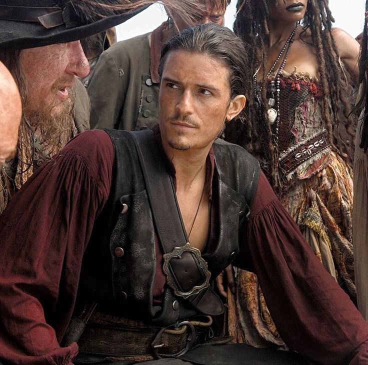 two men dressed in pirate garb sitting next to each other and one man with dreadlocks on his head