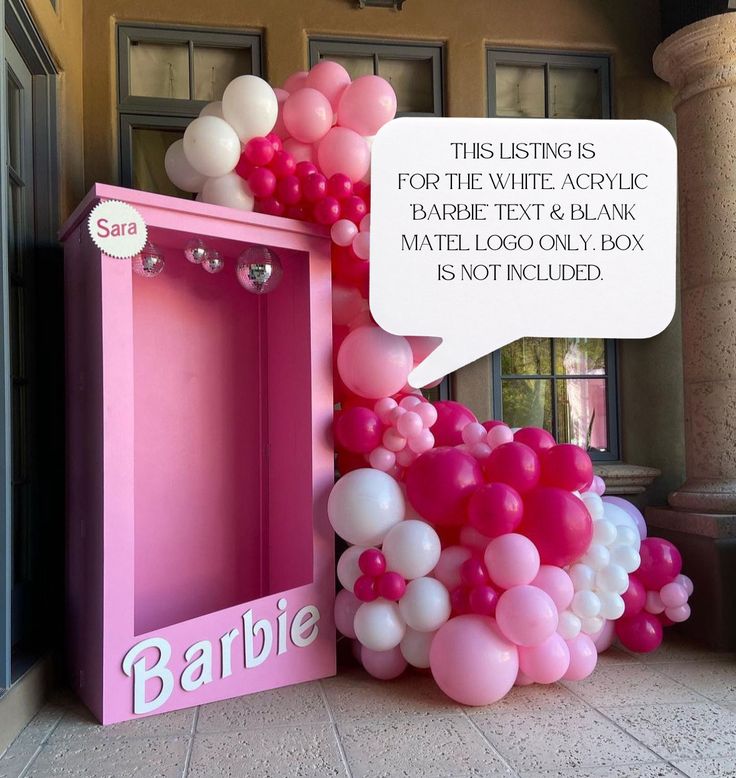 there is a pink box with balloons in it and a sign that says barbie above the door