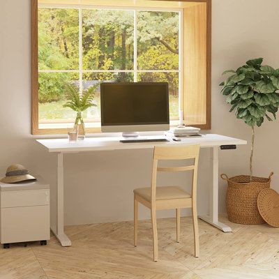 a white desk with a computer on it in front of a window and a potted plant