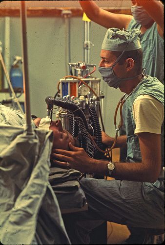 a man in a surgical mask working on a machine