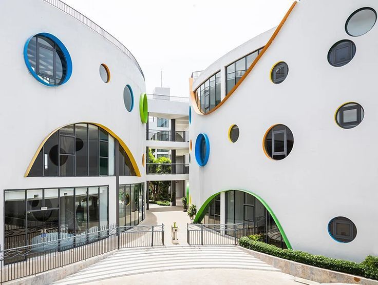 two buildings with circular windows on each side and an entry way leading to the second floor