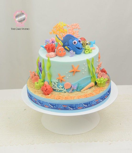 a blue and white cake with an ocean theme on the top is sitting on a table