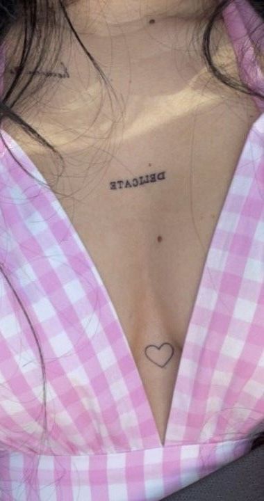 a woman with a heart tattoo on her chest