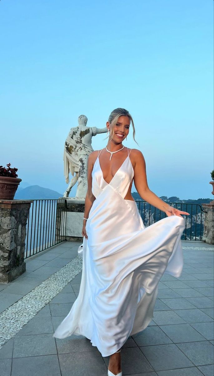 a woman in a white dress posing for the camera